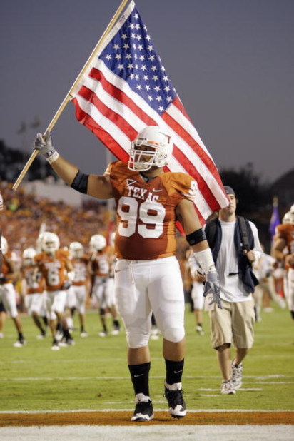 AUSTIN, TX - OCTOBER 18:  Roy Miller #99 of the Texas Longhorns carries an American flag onto the field before the game against the Missouri Tigers on October 18, 2008 at Darrell K Royal-Texas Memorial Stadium in Austin, Texas.  Texas won 56-31.  (Photo b