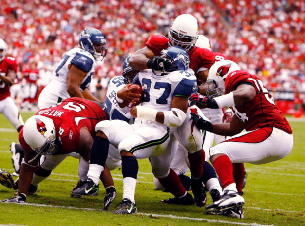 GLENDALE, AZ - SEPTEMBER 16:  Darnell Dockett #90 of the Arizona Cardinals wraps up Seattle Seahawks running back Shaun Alexander #37 as teammates Gerald Hayes #54 and Gabe Watson #98 come over to assist during the Cardinals 23-20 win at University of Pho