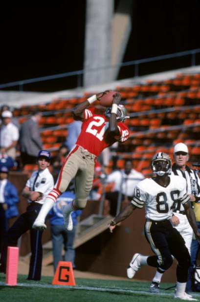 SAN FRANCISCO - SEPTEMBER 29:  Defensive back Eric Wright #21 of the San Francisco 49ers jumps to make an interception in front of wide receiver Eugene Goodlaw #88 of the New Orleans Saints during a game at Candlestick Park on September 29, 1985 in San Fr