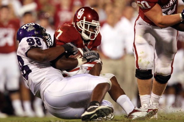 NORMAN, OK - SEPTEMBER 27:  Running back DeMarco Murray #7 of the Oklahoma Sooners is tackled by Jerry Hughes #98 of the TCU Horned Frogs at Memorial Stadium on September 27, 2008 in Norman, Oklahoma.  (Photo by Ronald Martinez/Getty Images)