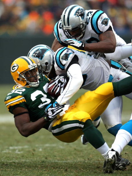 GREEN BAY, WI - NOVEMBER 30:  Brandon Jackson #32 of the Green Bay Packers is tackled by Thomas Davis #58 and Na'il Diggs #53 of the Carolina Panthers at Lambeau Field on November 30, 2008 in Green Bay, Wisconsin.  (Photo by Jonathan Daniel/Getty Images)
