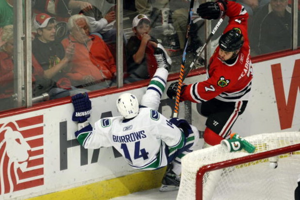 CHICAGO - MAY 11:  Brent Seabrook #7 of the Chicago Blackhawks knocks Alex Burrows #14 of the Vancouver Canucks down onto the ice during the third period of Game Six of the Western Conference Semifinal Round of the 2009 Stanley Cup Playoffs on May 11, 200