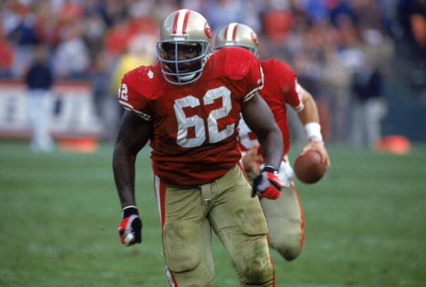 SAN FRANCISCO - NOVEMBER 15:  Guard Guy McIntyre #62 of the San Francisco 49ers is the lead blocker for running quarterback Steve Young #8 during a game against the New Orleans Saints at Candlestick Park on November 15, 1992 in San Francisco, California. 