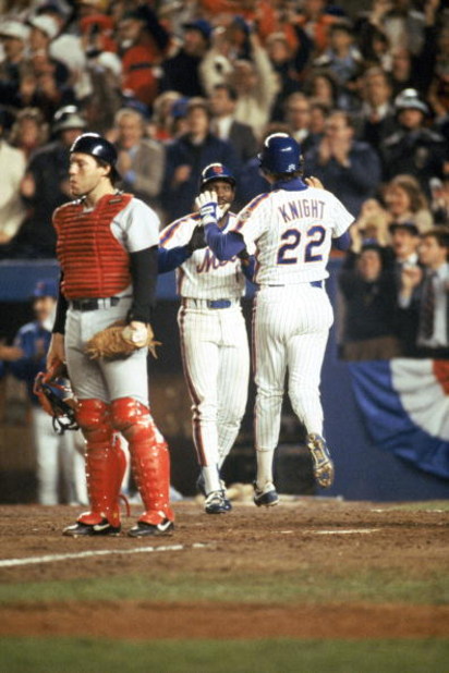 FLUSHING, NY - OCTOBER 27:  Third baseman Ray Knight #22 of the New York Mets gives teammate Mookie Wilson #1 a five during game 7 of the 1986 World Series against the Boston Red Sox at Shea Stadium in Flushing, New York. The Mets won the series 4-3.  (Ph