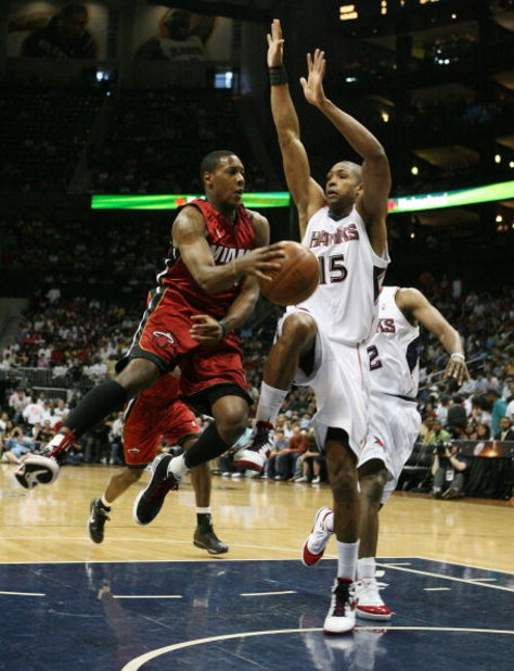 ATLANTA - MAY 03:  Mario Chalmers #6 of the Miami Heat passes around Al Horford #15 of the Atlanta Hawks during Game Seven of the Eastern Conference Quarterfinals at Philips Arena on May 3, 2009 in Atlanta, Georgia. The Hawks defeated the Heat 91-78. NOTE