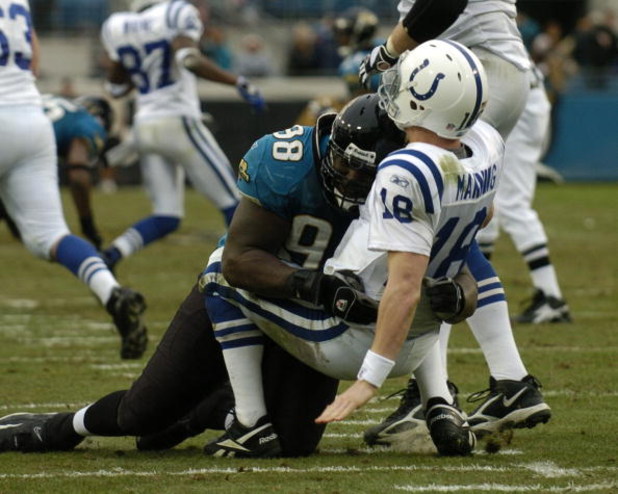 Indianapolis Colts quarterback Peyton Manning tumbles under the pass rush of  Jacksonville Jaguars  defensive tackle John Henderson December 11, 2005 in Jacksonville.  The Colts defeated the Jaguars 26 - 18 to remain undefeated.  (Photo by Al Messerschmid