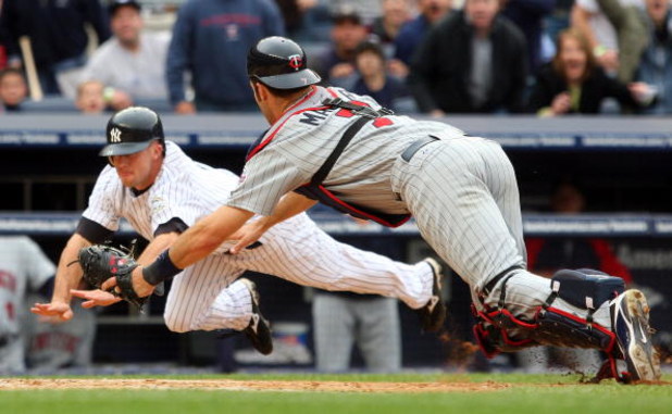 NEW YORK - MAY 17:  Joe Mauer #7 of the Minnesota Twins dives to tag out Brett Gardner #11 of the New York Yankees in the ninth inning on May 17, 2009 at Yankee Stadium in the Bronx borough of New York City. The Yankees defeated the Twins 3-2 in ten innin