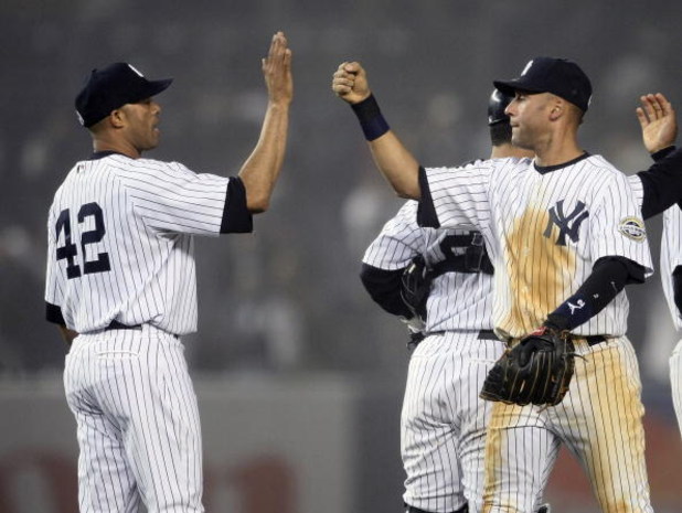 NEW YORK - APRIL 21:  Derek Jeter #2 of the New York Yankees celebrates their win against the Oakland Athletics with teammate Mariano Rivera #42 at Yankee Stadium April 21, 2009 in the Bronx borough of New York City.  (Photo by Nick Laham/Getty Images)