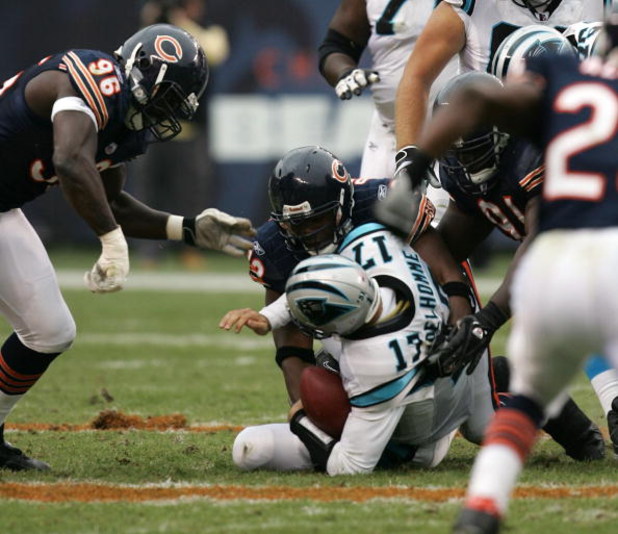 CHICAGO - NOVEMBER 20:  Adewale Ogunleye #93 of the Chicago Bears sacks Jake Delhomme #17 of the Carolina Panthers as Alex Brown #96 and Tommie Harris #91 of the Bears come to assist on November 20, 2005 at Soldier Field in Chicago, Illinois.  (Photo by J