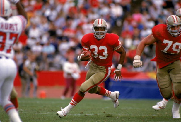 SAN FRANCISCO - OCTOBER 22:  Running back Roger Craig #33 of the San Francisco 49ers looks for room to run against the New England Patriots defense during a game at Candlestick Park on October 22, 1989 in San Francisco, California.  The 49ers won 37-20.  