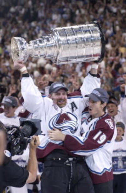 9 Jun 2001:  Ray Bourque #77 of the Colorado Avalanche lifts the cup as teammate Joe Sakic #19 hugs after the Colorado Avalanche defeated the New Jersey Devils 3-1 in game seven of the NHL Stanley Cup Finals at Pepsi Center in Denver, Colorado.  The Avala