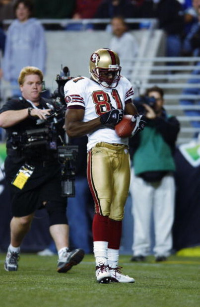 SEATTLE - OCTOBER 14:  Wide receiver Terrell Owens #81 of the San Francisco 49ers pulls a pen out of his sock and signs the football after scoring a touchdown against the Seattle Seahawks during their game on October 14, 2002 at Seahawks Stadium in Seattl