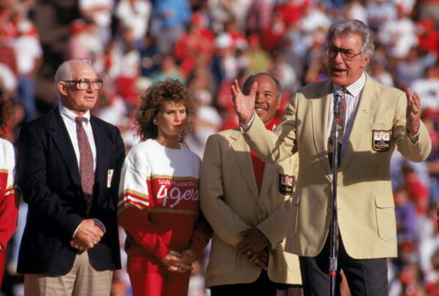 SAN FRANCISCO - NOVEMBER 18:  (L-R) 49ers Hall of Famers Y.A. Tittle, Joe Perry stand next to Bob St. Clair who speaks to the fans during a game between the San Francisco 49ers and Tampa Bay Buccaneers at Candlestick Park on November 18, 1990 in San Franc