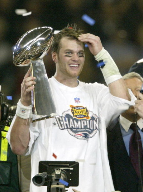 HOUSTON, TX - FEBRUARY 1:  MVP Tom Brady #12 of the New England Patriots raises the Lombardi trophy as he is interviewed by television commentator Jim Nance after defeating the Carolina Panthers 32-29 in Super Bowl XXXVIII at Reliant Stadium on February 1