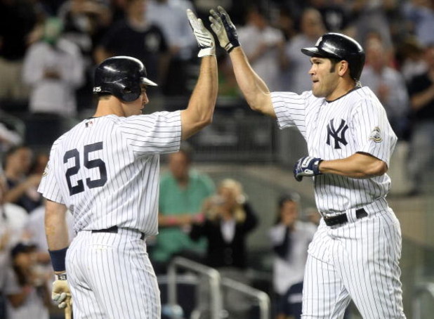 NEW YORK - JUNE 08:  Johnny Damon #18 of the New York Yankees celebrates his solo home run in the sixth inning with teammate Mark Teixeira #25 against the Tampa Bay Rays on June 8, 2009 at Yankee Stadium in the Bronx borough of New York City.  (Photo by N