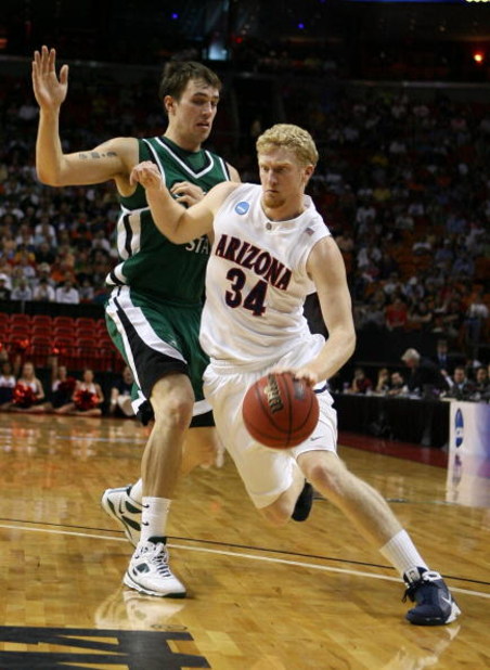 MIAMI - MARCH 22:  Forward Chase Budinger #34 of the University of Arizona Wildcats is defended by center Chris Moore #42 of the Cleveland State University Vikings during the second round of the NCAA Division I Men's Basketball Tournament at the American 