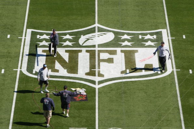TAMPA, FL - JANUARY 31:  Workers paint the NFL logo on center field a day before Super Bowl XLIII between the Arizona Cardinals and the Pittsburgh Steelers on January 31, 2009 at Raymond James Stadium in Tampa, Florida.  (Photo by Win McNamee/Getty Images