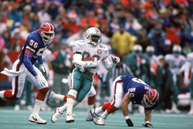 ORCHARD PARK, NY - DECEMBER 23: Wide receiver Mark Clayton #83 of the Miami Dolphins runs with the ball against the Buffalo Bills during a game at Ralph Wilson Stadium on December 23, 1990 in Orchard Park, New York. The Bills won 24-17. (Photo by Rick