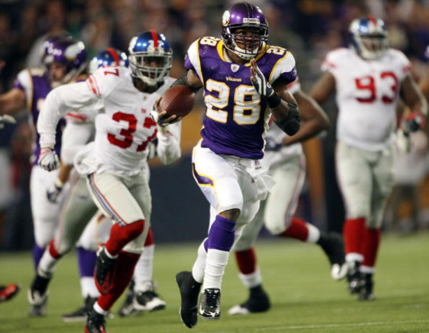 MINNEAPOLIS - DECEMBER 28:   Adrian Peterson #28 of the Minnesota Vikings runs the ball in for a touchdown as James Butler of the New York Giants defends on December 28, 2008 at the Hubert H. Humphrey Metrodome in Minneapolis, Minnesota. The Vikings defea