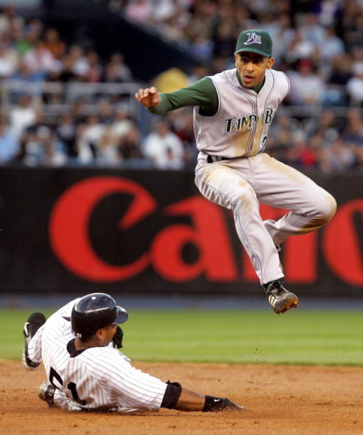 BRONX, NY - JUNE 20:  Julio Lugo #23 of the Tampa Bay Devil Rays jumps out of the way after forcing out Bernie Williams #51 of the New York Yankees at second base on June 20, 2005 at Yankee Stadium in the Bronx borough of New York City.  (Photo by Jim McI