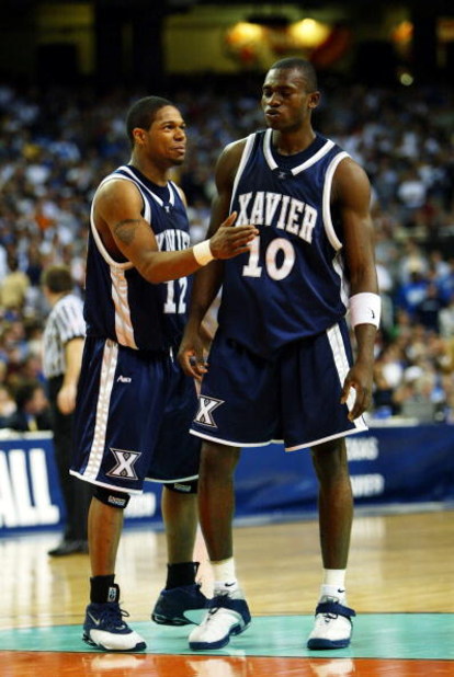 ATLANTA - MARCH 26:   Dedrick Finn #12 of the Xavier Muskateers congratulates Romain Sato #10 after Sato sinks a foul shot resulting from a technical foul against  the Texas Longhorns in the final seconds of the third round game of the NCAA Division I Men
