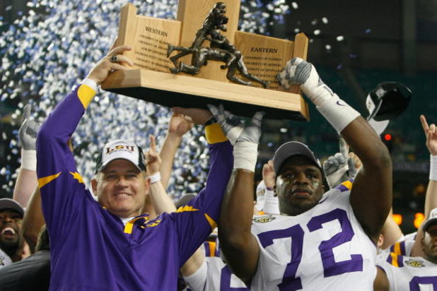 ATLANTA - DECEMBER 01:  Head coach Les Miles and Glenn Dorsey #72  of the Louisiana State University Tigers celebrate with the SEC trophy after defeating the University of Tennessee Volunteers 21-14 in the SEC Championship game on December 1, 2007 at the 