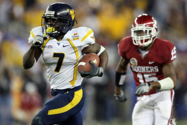 GLENDALE, AZ - JANUARY 02:  Running back Noel Devine #7 of the West Virginia Mountaineers runs for a 65-yard touchdown past Dominique Franks #15 of the Oklahoma Sooners in the second half at the Tostito's Fiesta Bowl at University of Phoenix Stadium Janua