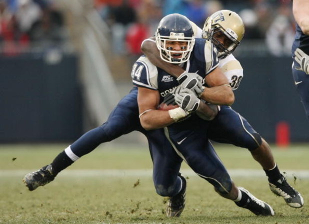 EAST HARTFORD, CT - DECEMBER 06: Donald Brown #34 of the Connecticut Huskies is taken down by Greg Williams #38 of the Pittsburgh Panthers on December 6, 2008 at Rentschler Field in East Hartford, Connecticut. Pittsburgh defeated Connecticut 34-10. (Pho