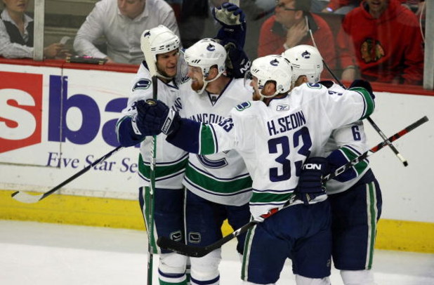 CHICAGO - MAY 11:  (L-R) Kevin Bieksa #3, Daniel Sedin #22, Henrik Sedin #33 and Sami Salo #6 of the Vancouver Canucks celebrate after Daniel Sedin scored a goal in the third period against the Chicago Blackhawks during Game Six of the Western Conference 