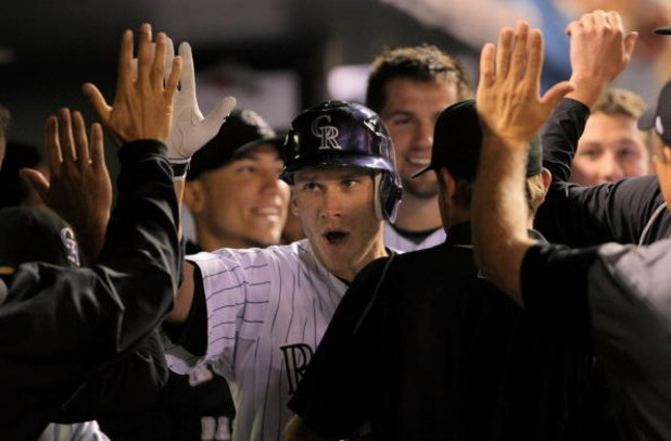 DENVER - AUGUST 25:  Clint Barmes #12 of the Colorado Rockies is congratulated by teammates on his seventh inning home run against the Los Angeles Dodgers at Coors Field on August 25, 2009 in Denver, Colorado. The Rockies defeated the Ddogers 5-4.  (Photo