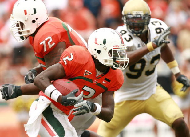 CORAL GABLES, FL - OCTOBER 13:  Running back Graig Cooper #2 of the Miami Hurricanes looks to get around defensive end Michael Johnson #93 of the Georgia Tech Yellow Jackets as he picks up a block from Andrew Bain #72 at the Orange Bowl on October 13, 200