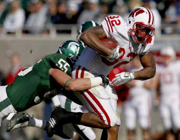 EAST LANSING, MI - NOVEMBER 01:  John Clay #32 of the Wisconsin Badgers tries for extra yards during a third quarter run in front of Adam Decker #55 of the Michigan State Spartans on November 1, 2008 at Spartan Stadium in East Lansing, Michigan. Michigan 