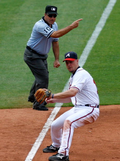 ATLANTA - AUGUST 01:  Third base umpire Phil Cuzzi #10 call a fair ball behind Chipper Jones #10 of the Atlanta Braves against the Los Angeles Dodgers on August 1, 2009 at Turner Field in Atlanta, Georgia.  (Photo by Kevin C. Cox/Getty Images)