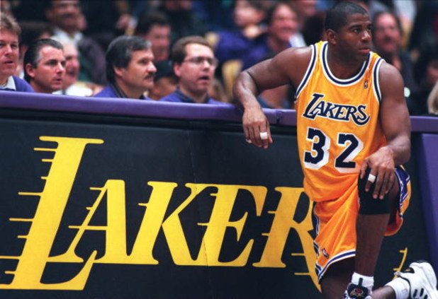 31 Jan 1996: Earvin Magic Johnson #32 of the Los Angeles Lakers kneels on the sidelines in his return to the NBA during the game against the Golden State Warriors at the Great Western Forum in Inglewood, California.