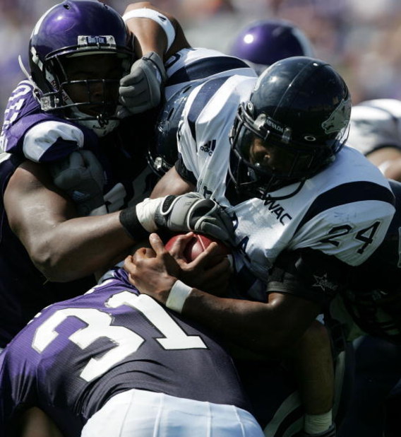 EVANSTON, IL - SEPTEMBER 08:  Brandon Fragger #24 of the Nevada Wolf Pack pushes the ball upfield as Corey Wootton #99 and Mike Dinard #31 of the Northwestern Wilcats attempt to bring him down on September 8, 2007 at Ryan Field at Northwestern University 