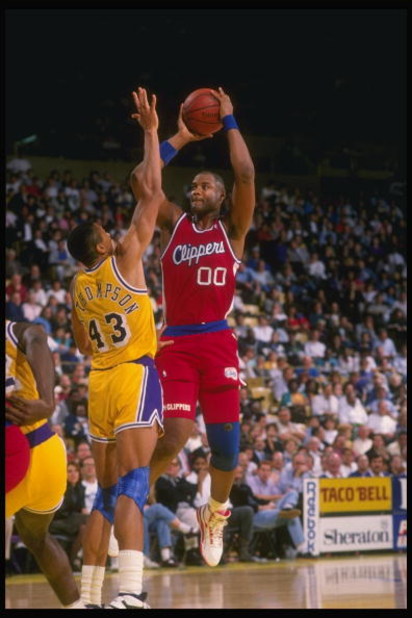 1989-1990:  Center Benoit Benjamin of the Los Angeles Clippers (right) tries to shoot the ball as Mychal Thompson of the Los Angeles Lakers blocks during a game at the Great Western Forum in Inglewood, California. Mandatory Credit: Ken Levine  /Allsport